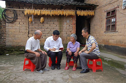 广西梧州市蒙山县蒙山镇北楼村党总支书记黄树新（左二）在北楼村文聚组贫困户中了解群众获得扶贫补助等情况。